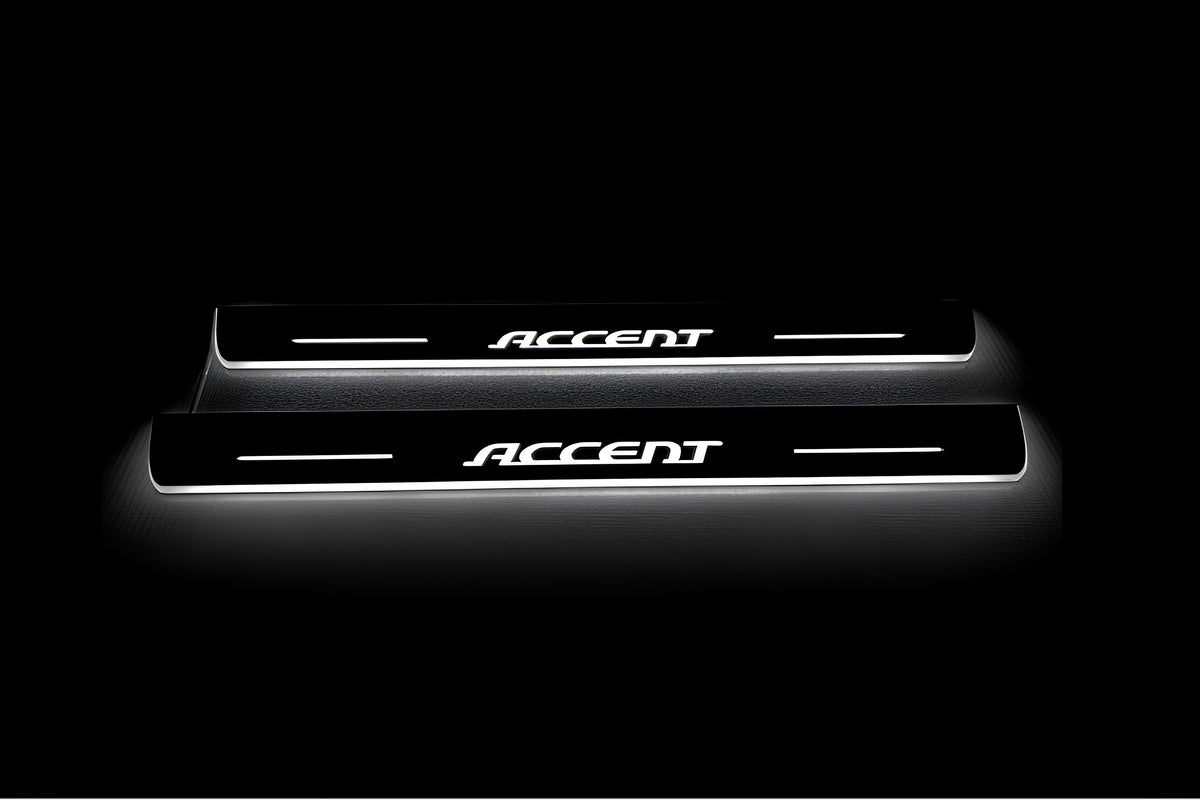 Two long door sill plates with Accent lettering and edges illuminated in white, straight-on view on a dark background.