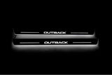 Two long door sill plates with Outback lettering and edges illuminated in white, straight-on view on a dark background.