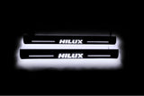 LED door sill plates Toyota Hilux VIII 2015+ in stainless steel with Hilux logo