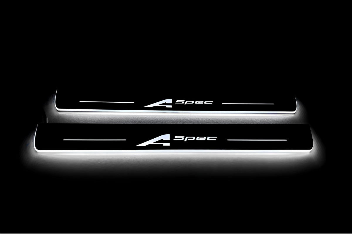 Two long door sill plates with A-Spec lettering and edges illuminated in white, straight-on view on a dark background.