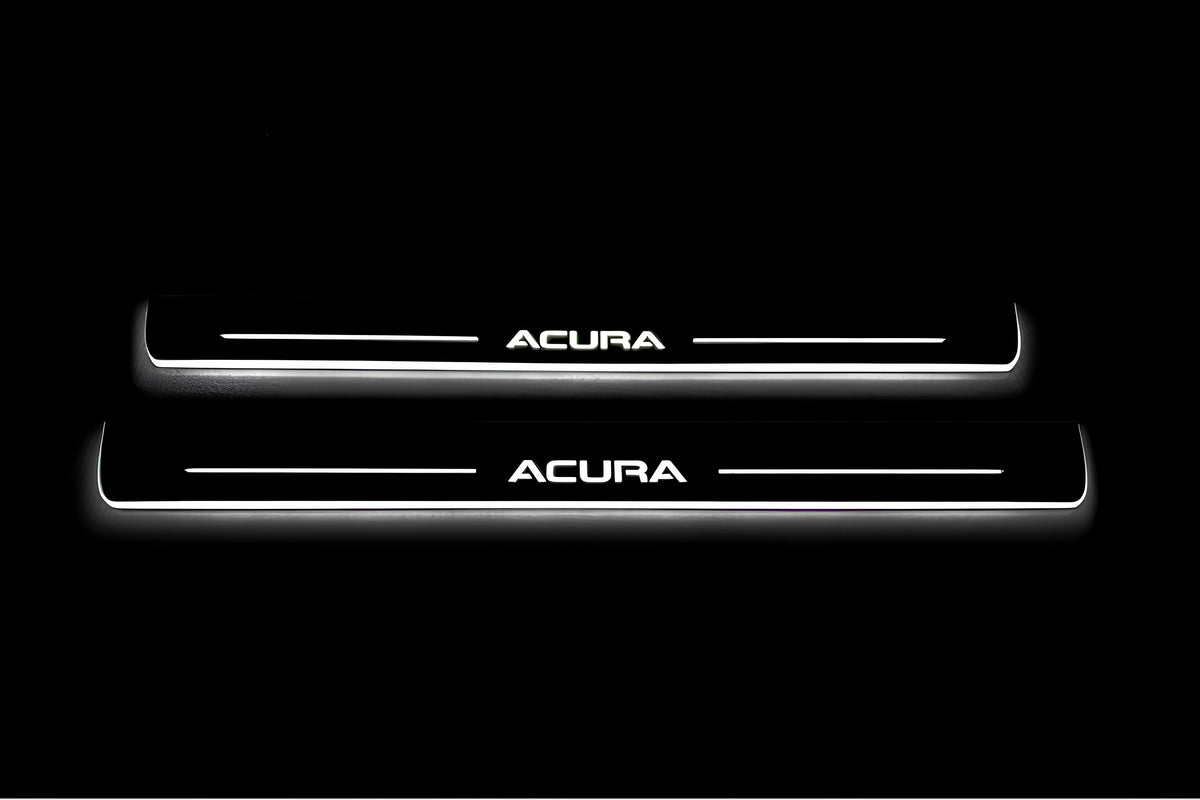 Two long door sill plates with Acura lettering and edges illuminated in white, straight-on view on a dark background.