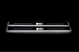 Two long door sill plates with H2 lettering and edges illuminated in white, straight-on view on a dark background.