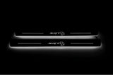 Two long door sill plates with SRT with a Hellcat head emblem lettering and edges illuminated in white, straight-on view on a dark background.