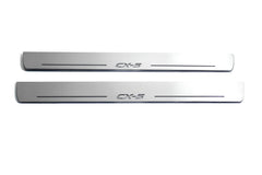 Two long silver-finished door sill plates with CX-5 lettering on a light background, straight-on view.