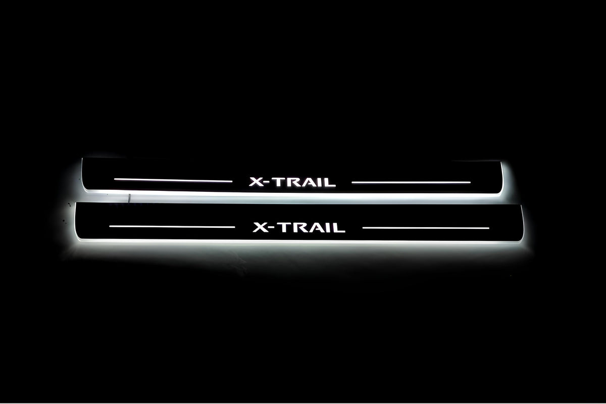 Two long door sill plates with X-Trail lettering and edges illuminated in white, straight-on view on a dark background.