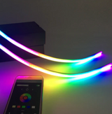 Multicolor illuminated door sill plates beside a smartphone color-control screen; Flow RGB demonstration.
