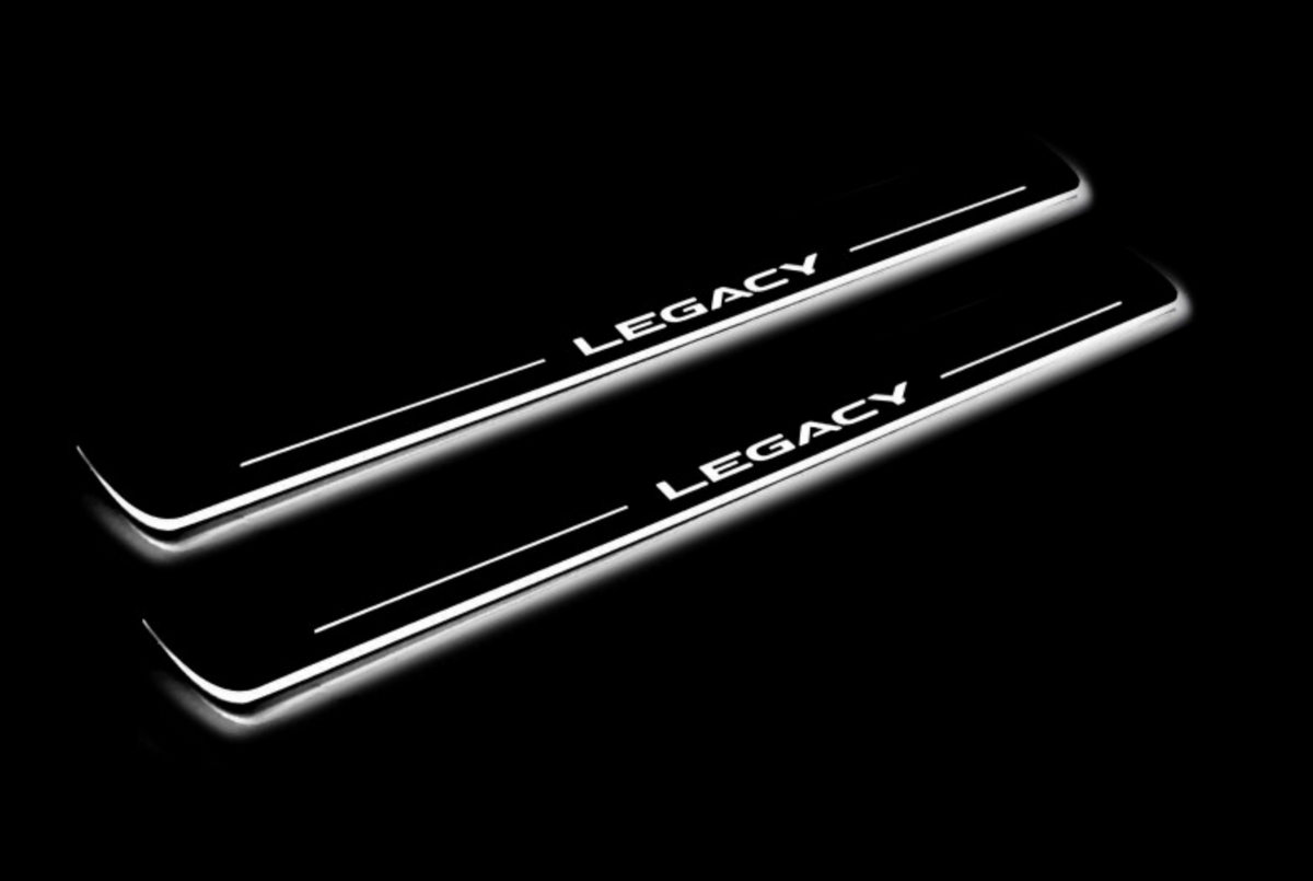 Two long door sill plates with Legacy lettering and edges illuminated in white, angled view on a dark background.