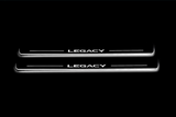 Two long door sill plates with Legacy lettering and edges illuminated in white, straight-on view on a dark background.