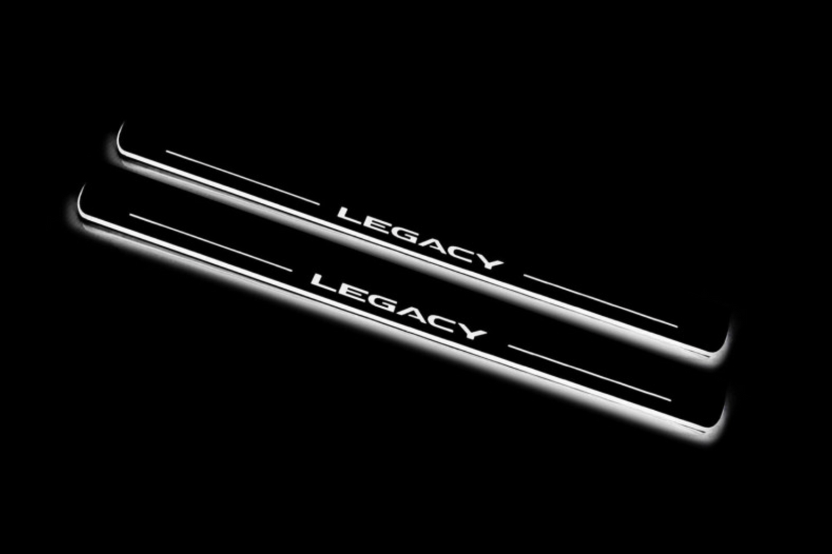 Two long door sill plates with Legacy lettering and edges illuminated in white, angled view on a dark background.
