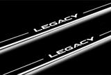 Close-up of Legacy lettering and illuminated edges on door sill plates against a dark background.
