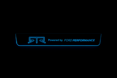 One door sill plate with an RTR emblem, Powered by FORD PERFORMANCE lettering and outlined edges illuminated blue on a dark background.