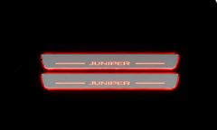 Two silver-faced door sill plates with Juniper lettering and edges illuminated red on a dark background.