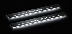 Two long door sill plates with Launch lettering and edges illuminated in white, angled view on a dark background.