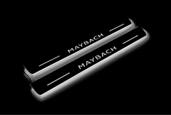 Two long door sill plates with Maybach lettering and edges illuminated in white, angled view on a dark background.