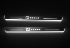 Two long door sill plates with Zeekr with rectangular emblems lettering and edges illuminated in white, straight-on view on a dark background.