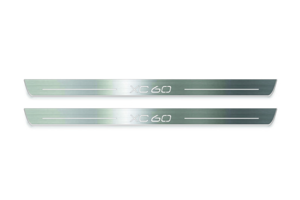 Two long silver-finished door sill plates with XC60 lettering on a light background, straight-on view.