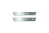 Two short silver-finished door sill plates with XC60 lettering on a light background, straight-on view.