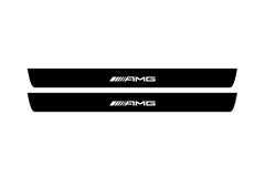 Catalog illustration of two black front door sill plates with AMG lettering.