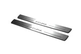 Two long silver-finished door sill plates with Acura lettering on a light background, angled view.