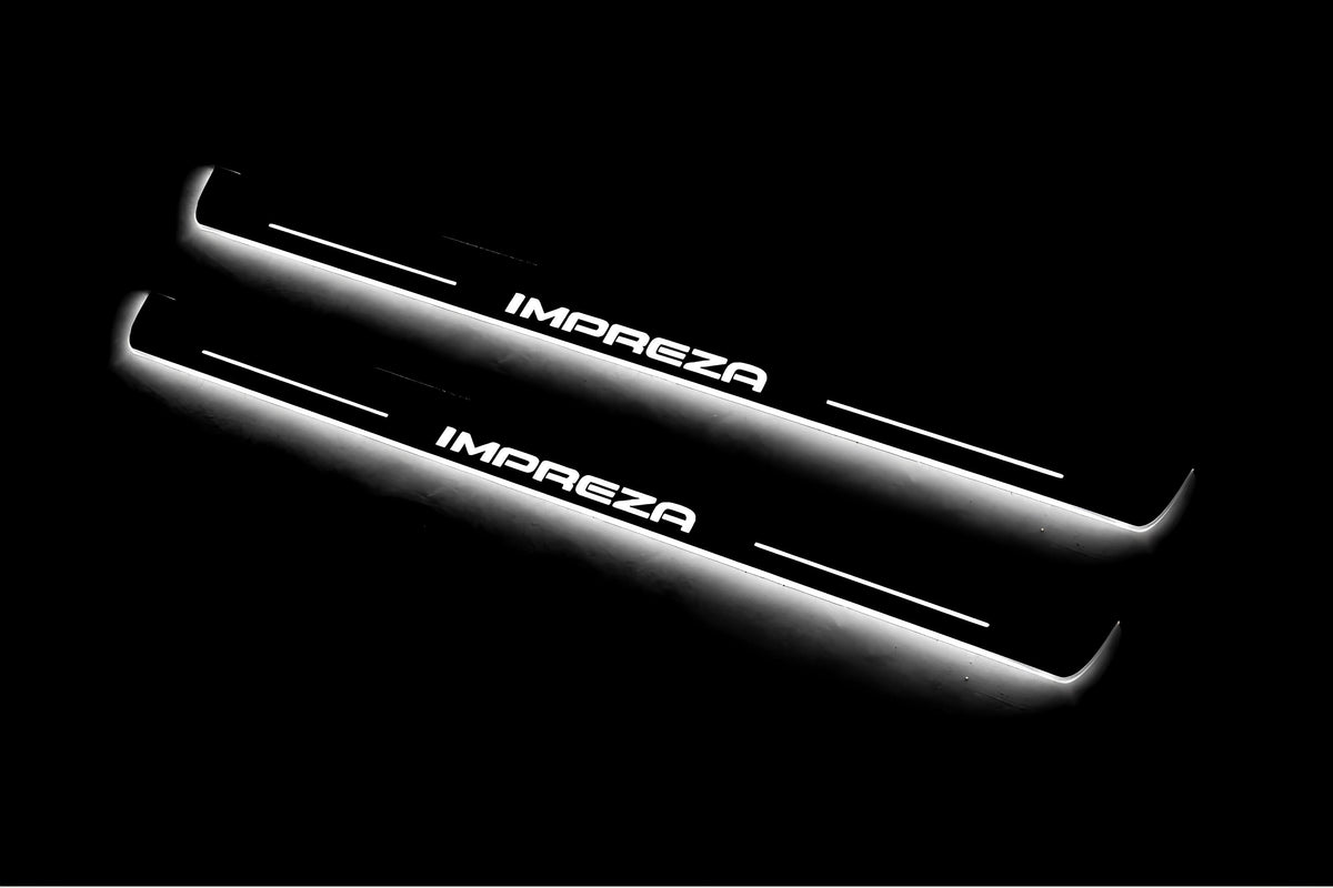 Two long door sill plates with Impreza lettering and edges illuminated in white, angled view on a dark background.
