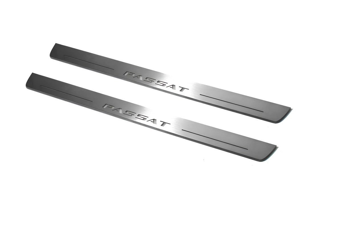 Two long silver-finished door sill plates with Passat lettering on a light background, angled view.