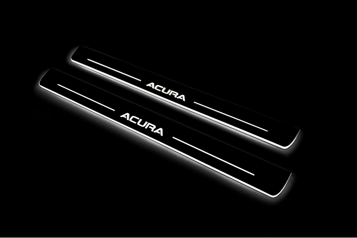 Two long door sill plates with Acura lettering and edges illuminated in white, angled view on a dark background.