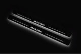 Two long door sill plates with Maxima lettering and edges illuminated in white, angled view on a dark background.