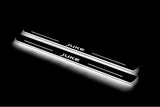Two long door sill plates with Juke lettering and edges illuminated in white, angled view on a dark background.
