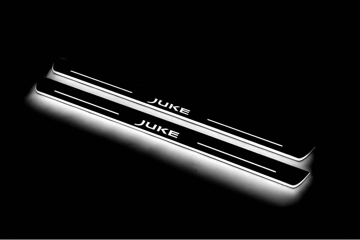 Two long door sill plates with Juke lettering and edges illuminated in white, angled view on a dark background.