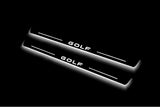 Two long door sill plates with Golf lettering and edges illuminated in white, angled view on a dark background.