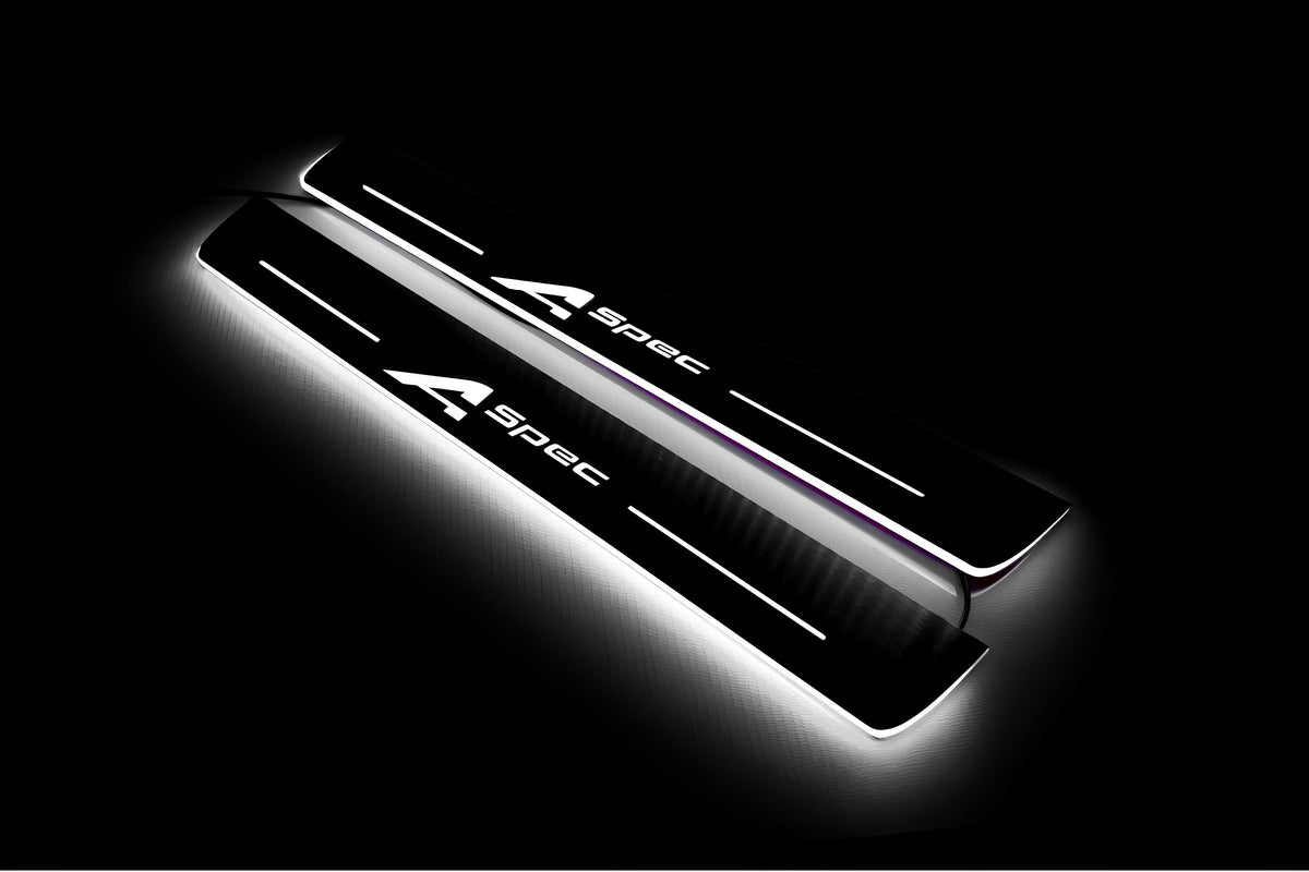Two long door sill plates with A-Spec lettering and edges illuminated in white, angled view on a dark background.