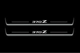 Two long door sill plates with 370Z lettering and edges illuminated in white, straight-on view on a dark background.