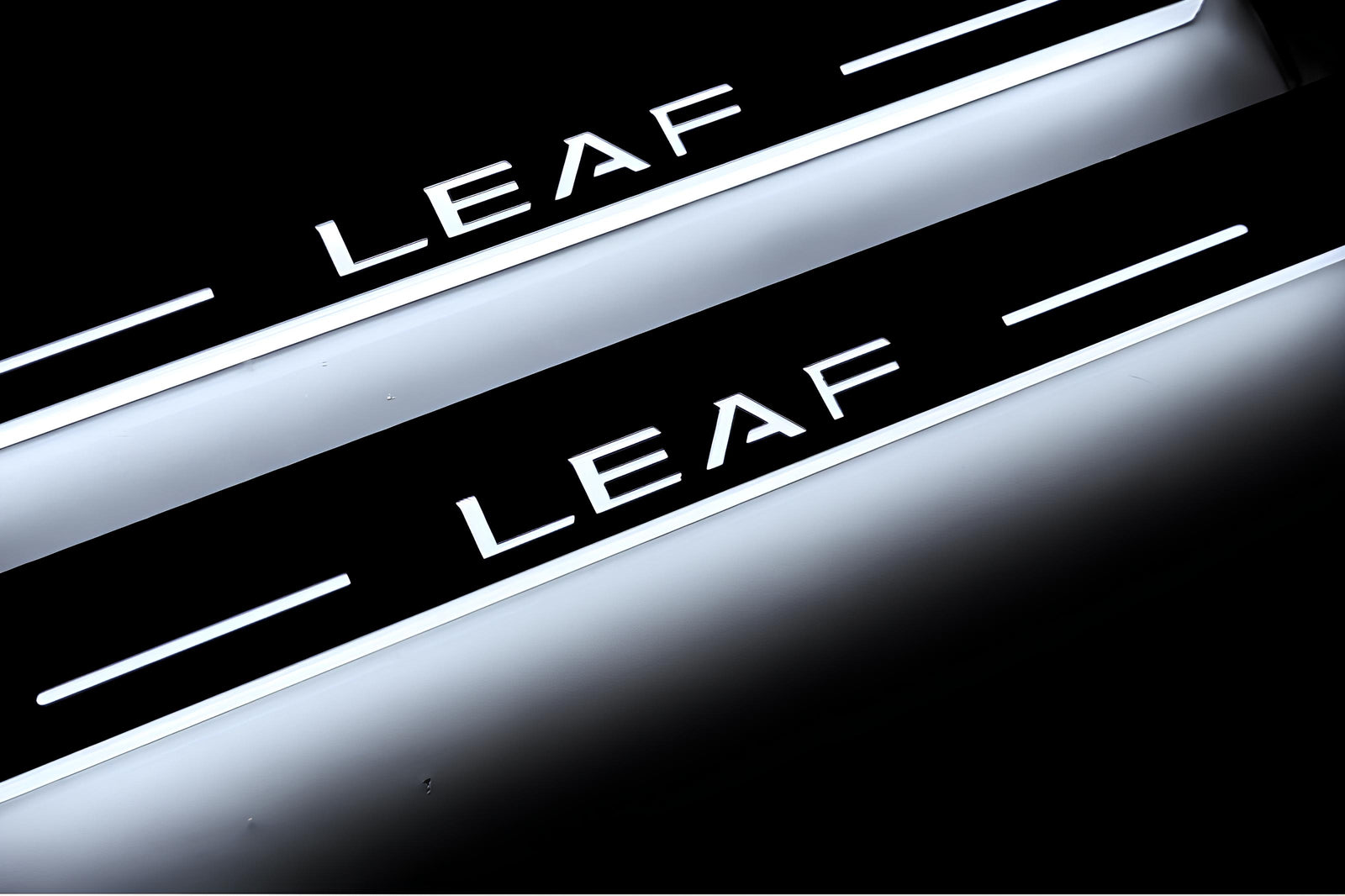 Nissan Leaf I 2010+ entry guards in stainless steel with Leaf logo