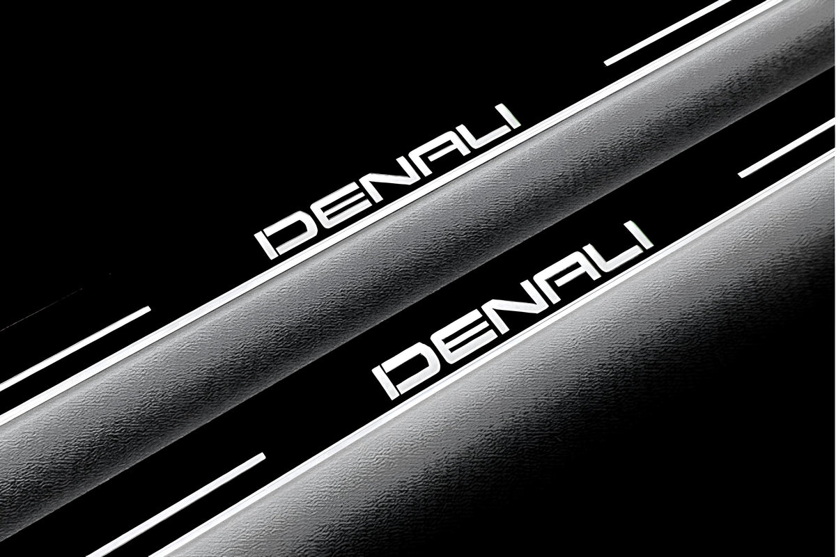 Close-up of Denali lettering and illuminated edges on door sill plates against a dark background.