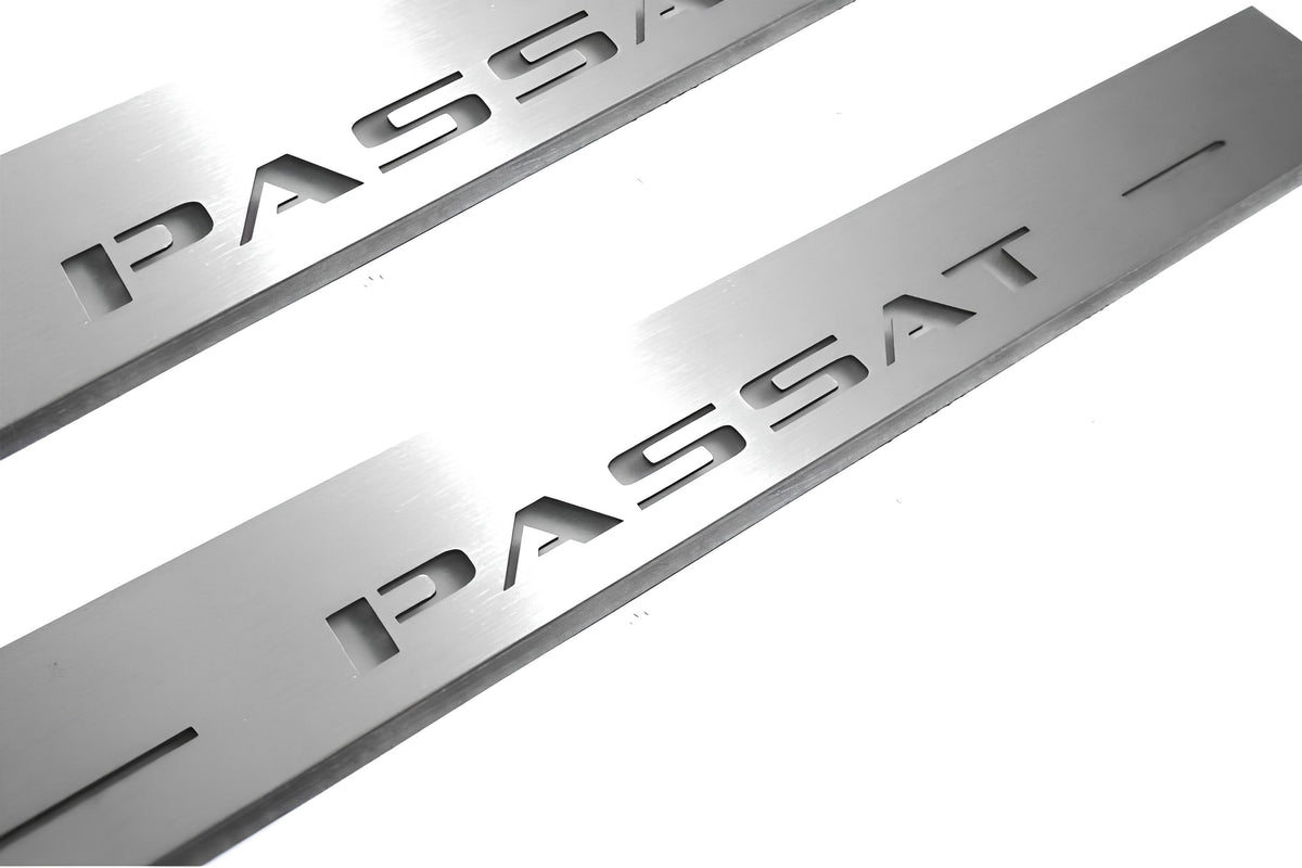 Close-up of Passat lettering and linear slots in silver-finished door sill plates.