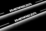 Close-up of Impreza lettering and illuminated edges on door sill plates against a dark background.