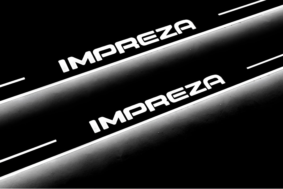 Close-up of Impreza lettering and illuminated edges on door sill plates against a dark background.