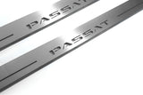 Close-up of Passat lettering and linear slots in silver-finished door sill plates.