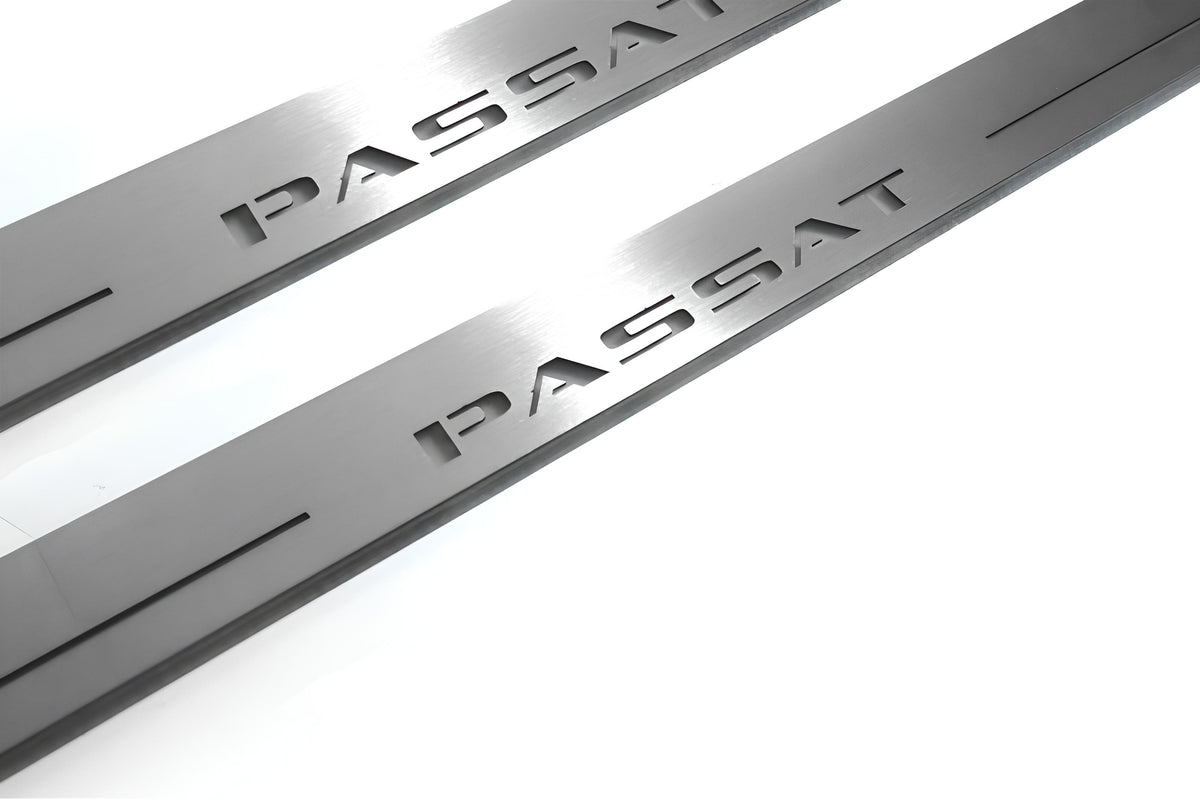 Close-up of Passat lettering and linear slots in silver-finished door sill plates.
