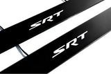 Close-up of black door sill plates with white SRT lettering.