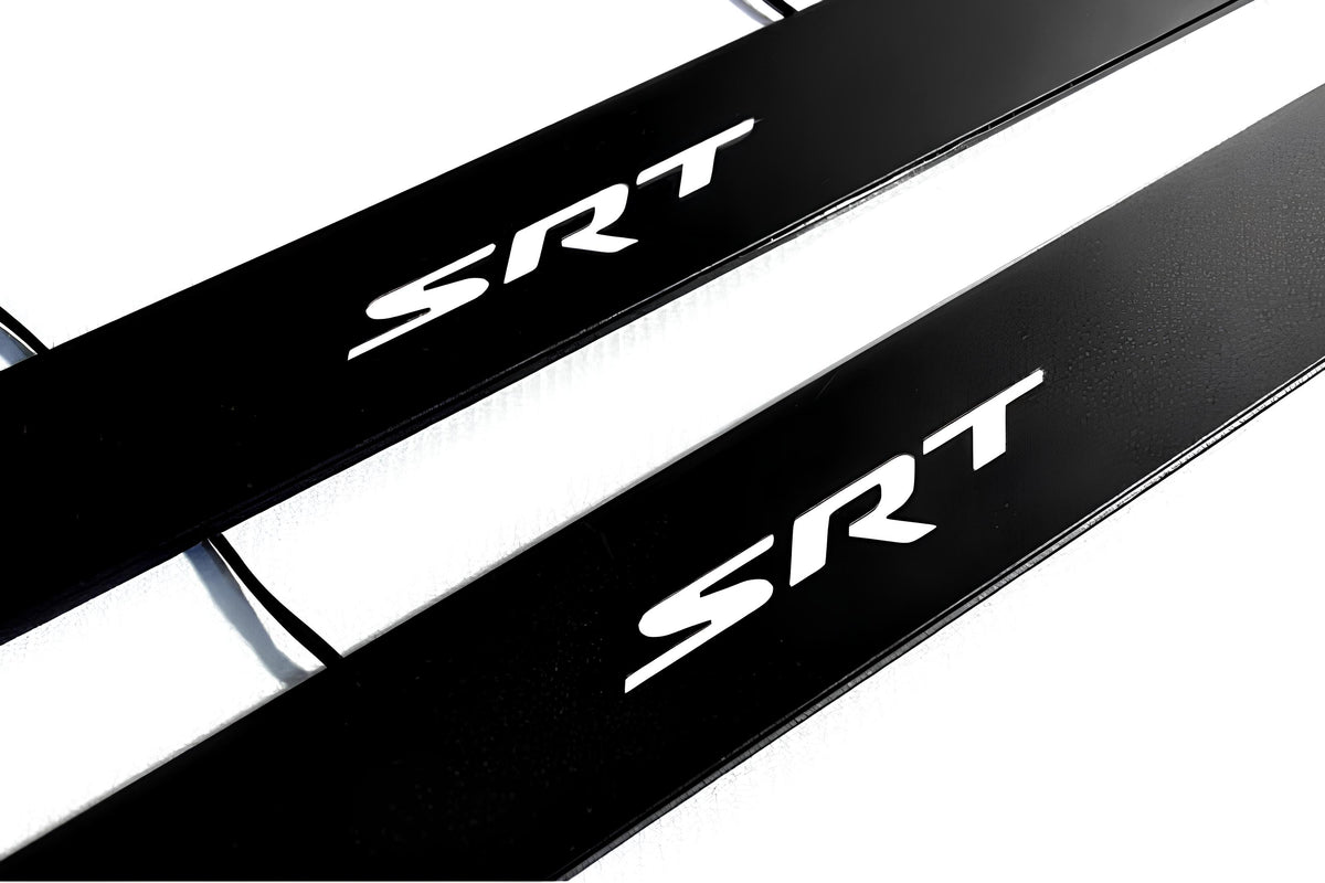 Close-up of black door sill plates with white SRT lettering.
