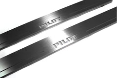Close-up of Pilot lettering and linear slots in silver-finished door sill plates.