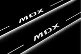 Close-up of MDX lettering and illuminated edges on door sill plates against a dark background.
