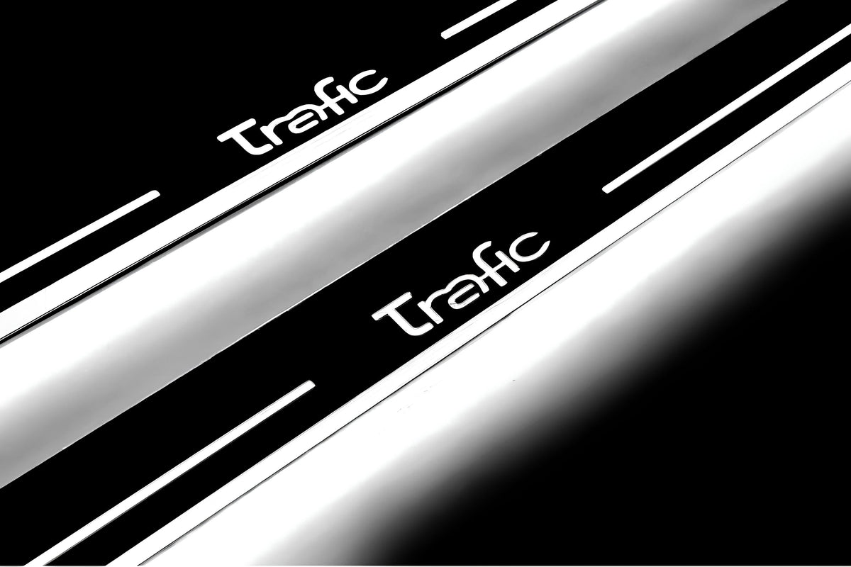 Close-up of Trafic lettering and illuminated edges on door sill plates against a dark background.
