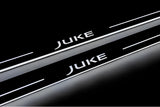 Close-up of Juke lettering and illuminated edges on door sill plates against a dark background.