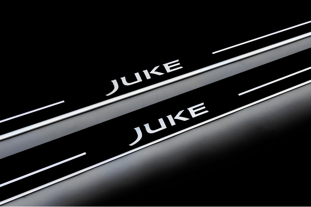 Close-up of Juke lettering and illuminated edges on door sill plates against a dark background.