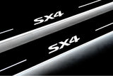 Close-up of SX4 lettering and illuminated edges on door sill plates against a dark background.