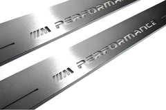 Close-up of M Performance lettering and linear slots in silver-finished door sill plates.
