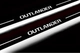 Close-up of Outlander lettering and illuminated edges on door sill plates against a dark background.