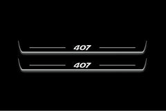 Two long door sill plates with 407 lettering and edges illuminated in white, straight-on view on a dark background.